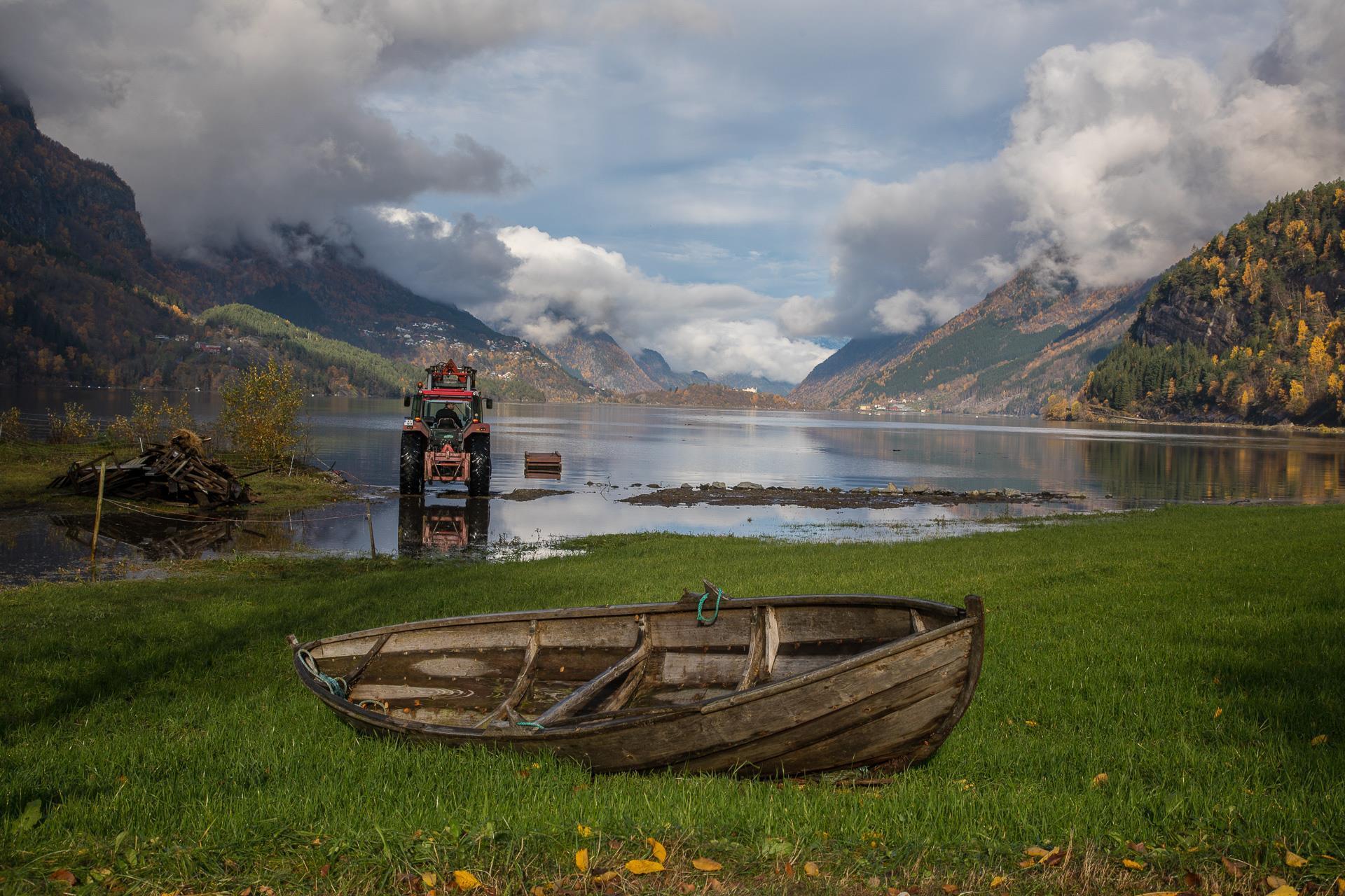 Gamal trebåt på grasplen med Sandvinsvatnet i bakgrunn. Foto.