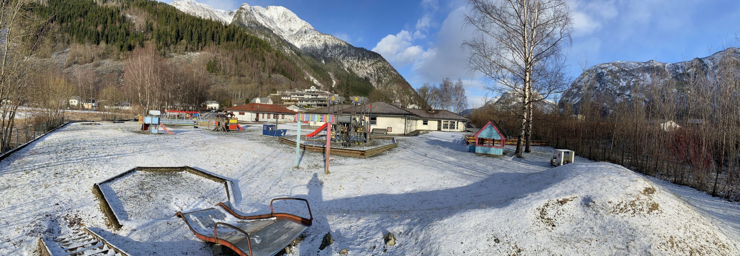 Eitrheimsvågen barnehage ein vinterdag med snødekt leikeområde med barnehagen i bakgrunn. Bilete.