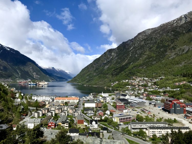 Utsyn over Odda by i fint vær med fjord og fjell. Foto.
