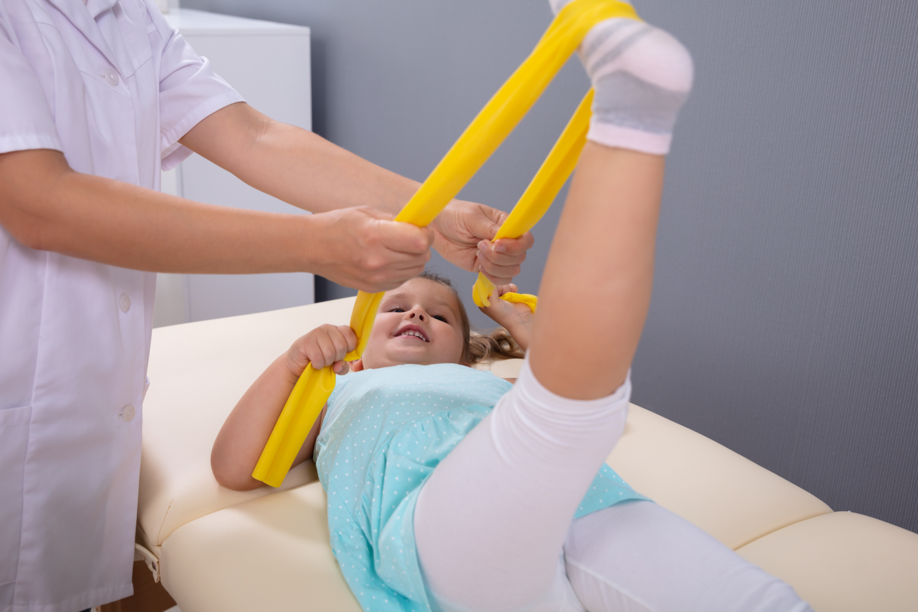 Fysioterapeut som hjelper jente med å tøye fot